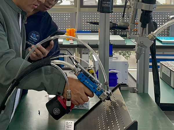 參觀人員試用速耐自動拉釘機(jī)